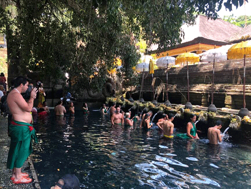 Du khách tắm rửa để tẩy trần tại dòng nước thiêng ở đền suối thiêng Tampak Siring Holy Water Spring. 