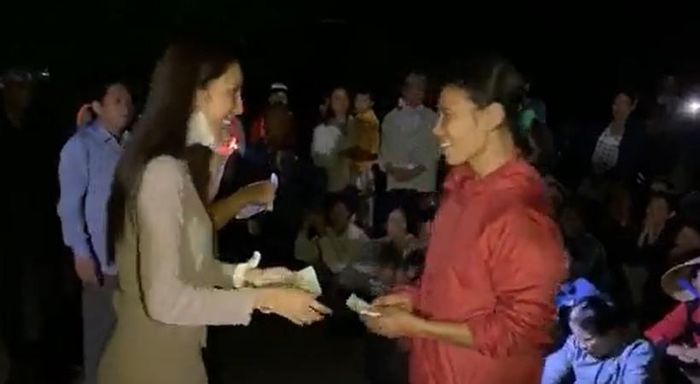 Thủy Tiên phát tiền từ thiện cho bà con. (Ảnh: chụp từ livestream).